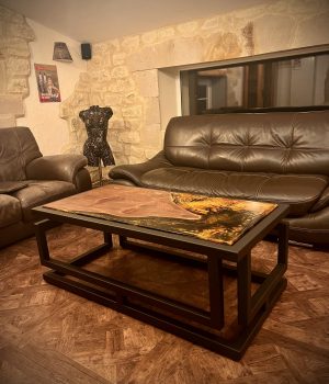 Table basse avec contour en métal. Pour le plateau, mélange de bois et de résine époxy.