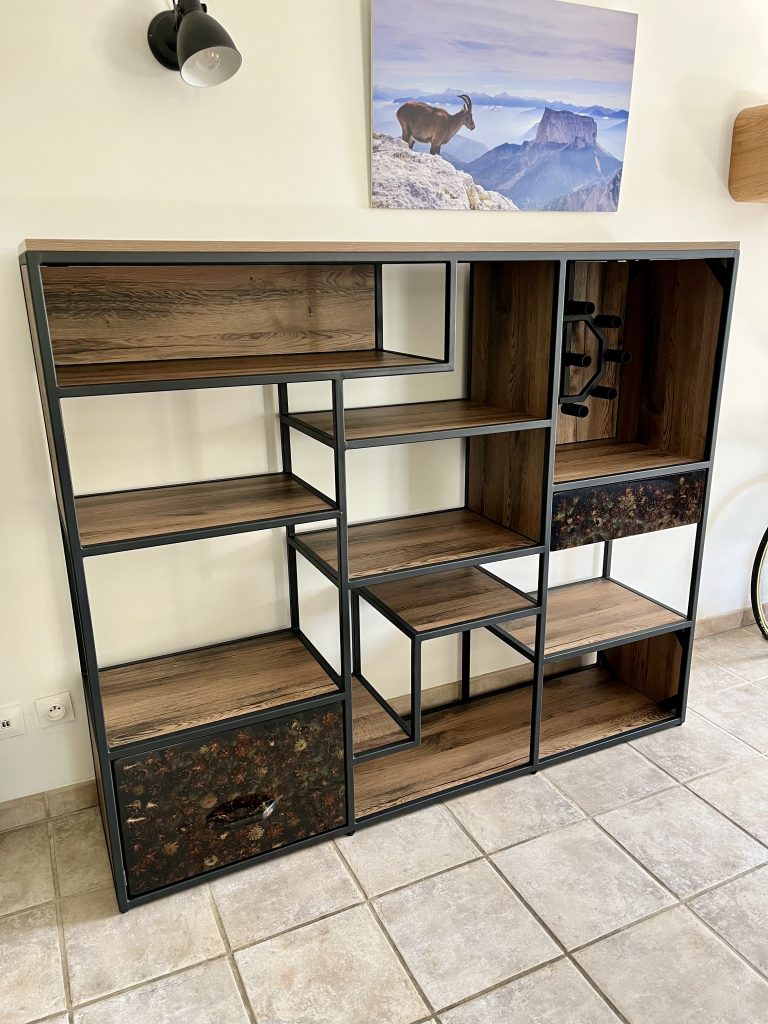 Meuble en métal et bois. Les tiroirs sont des pommes de pin recouvertes de résine époxy transparente. Dans une case, un porte bouteille pouvant en contenir 9.