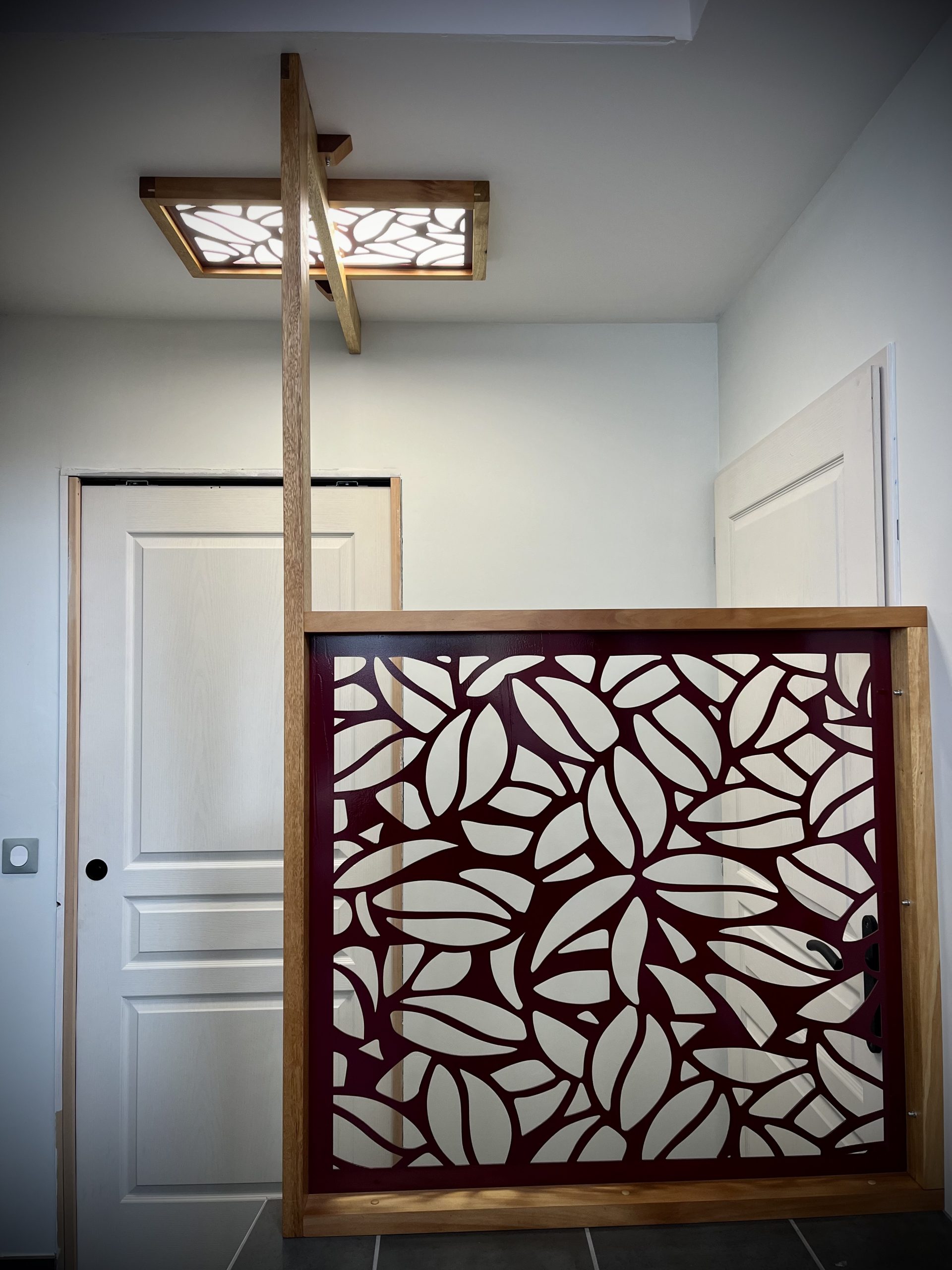 Garde Corps pour sublimer un escalier en bois et métal. Luminaire intégré au design. Motif personnalisable et découpé dans la tôle d'acier.