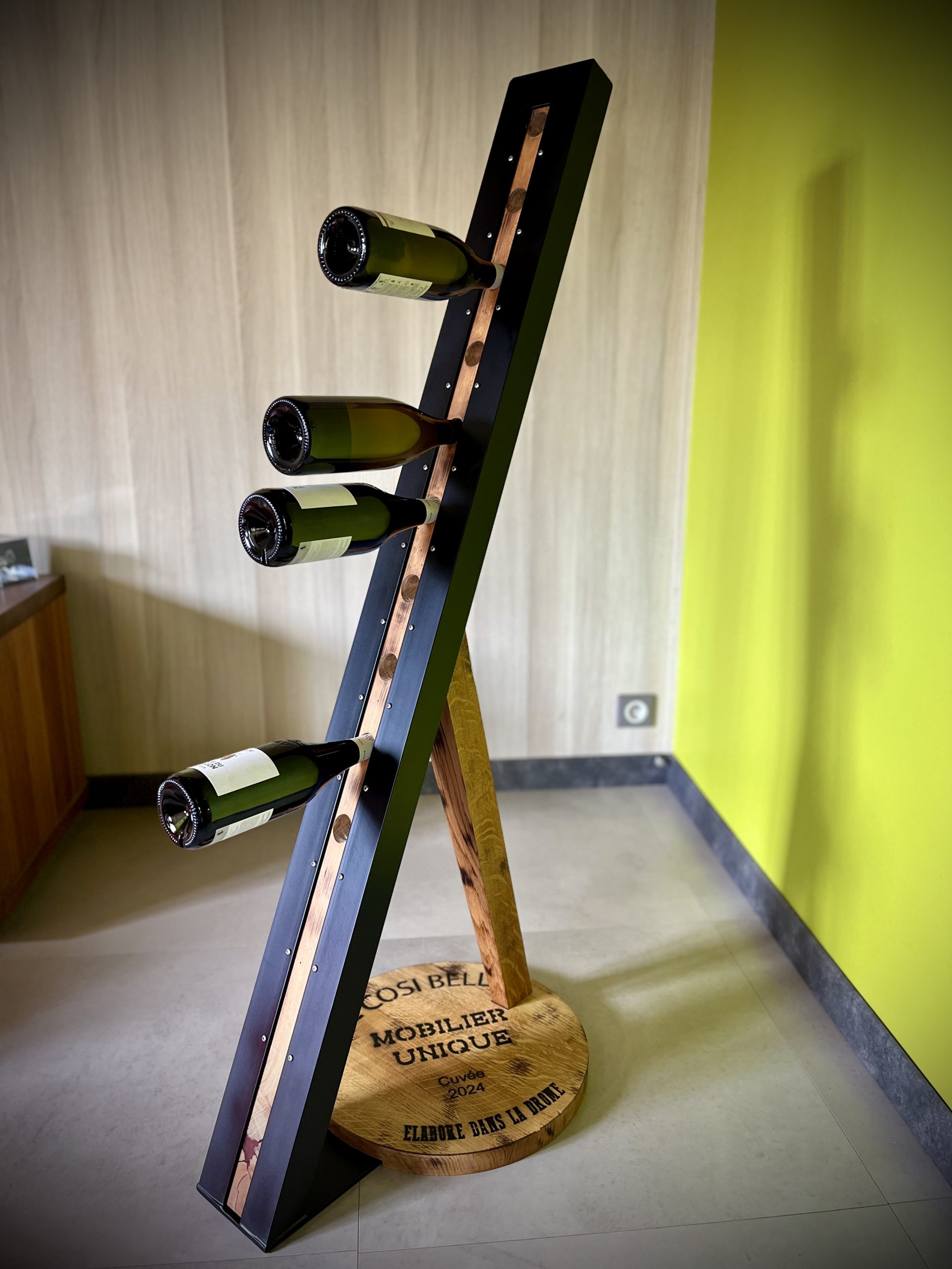 Un présentoir en bois massif et acier. Un véritable meuble de décoration pour mettre en valeur vos plus belles bouteilles. L'écriture sur l'embase est personnalisable.