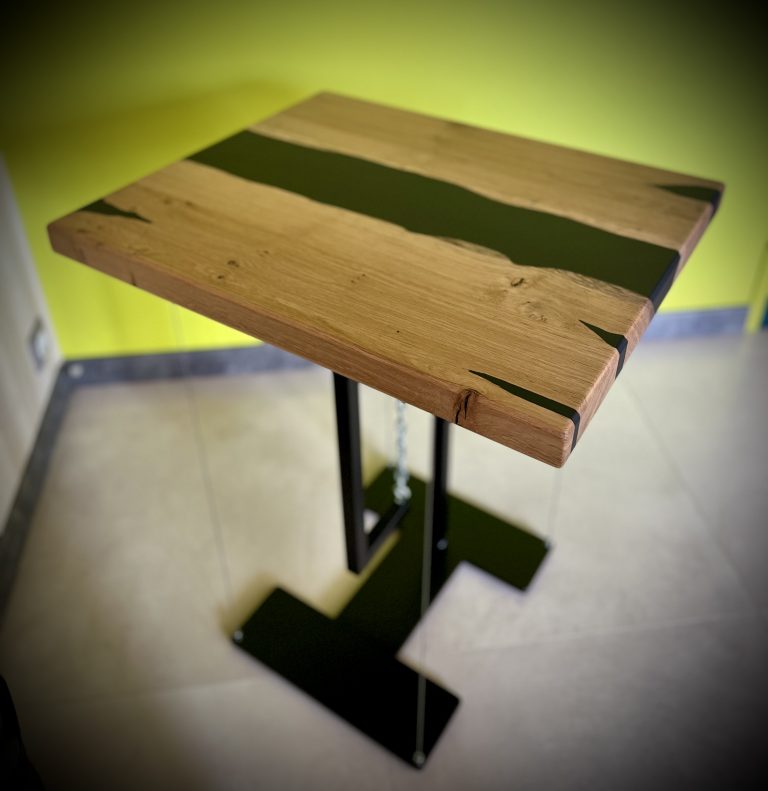 Table suspendue, plateau en chêne massif, rivière en résine epoxy noir, vernissage incolore mat. Ferronnerie et peinture pour le piètement. Un brin d'imagination et de réflexion pour le système de suspension..